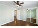 This bedroom features neutral paint, wood floors, a ceiling fan, and a mirrored closet at 3911 Ivy Ne Rd, Atlanta, GA 30342