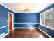 Dining room features hardwood floors, bright blue walls, and natural light at 3911 Ivy Ne Rd, Atlanta, GA 30342