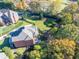 Aerial view of a property with a pool, playground, well manicured backyard, and mature trees at 3955 Graystone Preserve Pl, Cumming, GA 30040