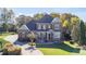 Stately brick home with lush landscaping, circular driveway, and welcoming covered front porch at 3955 Graystone Preserve Pl, Cumming, GA 30040