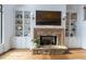 Stone fireplace flanked by built-in shelves in the living room with decorative items at 3955 Graystone Preserve Pl, Cumming, GA 30040