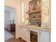 Custom bar with beverage refrigerator, sink, marble countertop and backsplash at 3955 Graystone Preserve Pl, Cumming, GA 30040