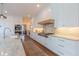 Gourmet kitchen showcasing white cabinetry, stainless appliances, and marble countertops and backsplash at 3955 Graystone Preserve Pl, Cumming, GA 30040