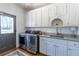 Clean laundry area with updated machines, white cabinets, and a stylish rug at 3955 Graystone Preserve Pl, Cumming, GA 30040