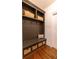 Mudroom boasts custom built-in shelving with baskets, bench seating, and wood floors at 3955 Graystone Preserve Pl, Cumming, GA 30040