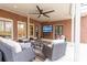 Inviting covered patio with brick surround, ceiling fan, and comfortable wicker furniture at 3955 Graystone Preserve Pl, Cumming, GA 30040