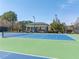 Well-maintained tennis court featuring blue and green surfaces, net, and shaded seating area at 3955 Graystone Preserve Pl, Cumming, GA 30040