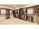 Spacious walk-in closet with custom shelving, rods, and plenty of storage space at 3955 Graystone Preserve Pl, Cumming, GA 30040