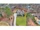 Aerial view of house showcasing its well-manicured lawn, extended driveway, and mature trees surrounding the property at 12867 Etris Walk, Roswell, GA 30075