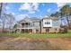 Back of house with a covered porch, an uncovered deck, windows, and a grassy yard at 12867 Etris Walk, Roswell, GA 30075