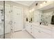 Bright bathroom featuring dual sinks, modern fixtures, marble countertops, and a glass-enclosed shower at 12867 Etris Walk, Roswell, GA 30075