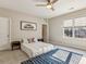 Bedroom with a car painting, modern ceiling fan, and lots of natural light at 12867 Etris Walk, Roswell, GA 30075