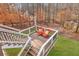 Wooden deck with white railings overlooking a wooded backyard with two orange Adirondack chairs at 12867 Etris Walk, Roswell, GA 30075