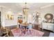 Dining area showcases hardwood floors, modern decor, statement chandelier, and transitions to staircase at 12867 Etris Walk, Roswell, GA 30075