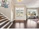 Inviting foyer featuring wood floors, staircase, gallery wall and glass front door allowing natural light at 12867 Etris Walk, Roswell, GA 30075