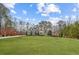Beautiful front exterior of a home with manicured lawn, mature trees, and a welcoming yellow door at 12867 Etris Walk, Roswell, GA 30075