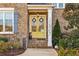 Close-up of front porch with yellow doors, brick steps, and lovely landscaping at 12867 Etris Walk, Roswell, GA 30075