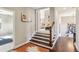 Bright hallway featuring hardwood floors, a staircase and doorway to a bedroom at 12867 Etris Walk, Roswell, GA 30075