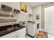 A modern laundry room with black granite countertops, overhead storage, and a new washer and dryer at 12867 Etris Walk, Roswell, GA 30075