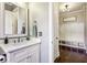 Bright powder room with white vanity, elegant mirror, and stylish fixtures located near the mud room at 12867 Etris Walk, Roswell, GA 30075