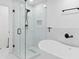 A modern bathroom features a glass shower with black finishings and a soaking tub at 1819 Avon Ave, Atlanta, GA 30311