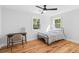A cozy bedroom features hardwood floors, two windows and minimalist decor at 1819 Avon Ave, Atlanta, GA 30311