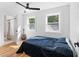 Airy bedroom with hardwood floors, white walls, two windows, and a ceiling fan, creating a cozy and well-lit space at 1819 Avon Ave, Atlanta, GA 30311
