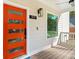 Close-up of a modern orange front door with glass inserts and stylish exterior lighting at 1819 Avon Ave, Atlanta, GA 30311