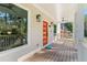 Inviting front porch featuring a modern orange door, ceiling fan, and stylish lighting fixtures at 1819 Avon Ave, Atlanta, GA 30311