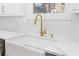 Close up of a kitchen sink with a gold faucet and a herringbone backsplash at 1819 Avon Ave, Atlanta, GA 30311