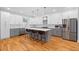 Modern kitchen featuring stainless steel appliances, a spacious island, and stylish lighting at 1819 Avon Ave, Atlanta, GA 30311