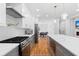 Long kitchen with stainless steel appliances, white cabinets, and grey lower cabinets and island at 1819 Avon Ave, Atlanta, GA 30311