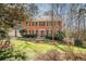 Charming two-story brick home with a well-manicured lawn, mature trees, and classic architectural details at 3762 Frederica Rd, Berkeley Lake, GA 30096