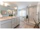 Bathroom featuring a double vanity, glass-enclosed shower, and soaking tub at 592 Moreland Ne Ave, Atlanta, GA 30307