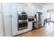 Chef's kitchen with built-in ovens, modern stainless steel refrigerator, and ample cabinet space at 592 Moreland Ne Ave, Atlanta, GA 30307