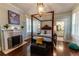 Bright main bedroom with a fireplace, decorative painting, and a doorway leading to the bathroom at 592 Moreland Ne Ave, Atlanta, GA 30307