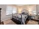 A cozy bedroom featuring hardwood floors, neutral colors, a metal bed frame and large window at 1888 Colt Dr, Atlanta, GA 30341