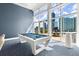 This billiard room features floor to ceiling windows and a white billiard table at 3325 Piedmont Ne Rd # 1504, Atlanta, GA 30305