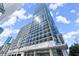 Modern glass high-rise building exterior on a sunny day with blue skies and puffy white clouds at 3325 Piedmont Ne Rd # 1504, Atlanta, GA 30305
