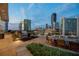 A stunning city skyline view from an expansive patio featuring a built-in outdoor kitchen and dining area at 3325 Piedmont Ne Rd # 1504, Atlanta, GA 30305