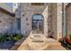 Close-up of elegant brick home's arched doorway and meticulous landscaping at 426 Lanesborough Dr, Marietta, GA 30064