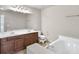 Bathroom featuring double vanity sinks, a large mirror, and a soaking tub at 1100 N North Village Drive Dr, Decatur, GA 30032