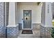 Inviting front entry with a gray painted door, brick columns, and a stylish welcome mat at 1100 N North Village Drive Dr, Decatur, GA 30032