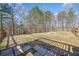 A large, unfenced backyard with an additional concrete patio and a wooded border beyond at 237 Elmbrook Ln, Canton, GA 30114