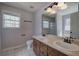 Bathroom with dual sinks, white toilet, wood cabinets, and natural light at 26 Wey Bridge Ct, White, GA 30184