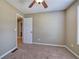 Cozy carpeted bedroom features neutral walls, ceiling fan, and a glimpse into connecting space at 26 Wey Bridge Ct, White, GA 30184