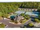 Aerial view of community clubhouse, swimming pool and tennis courts surrounded by lush trees and a landscaped parking area at 5080 Riverlake Dr, Peachtree Corners, GA 30097