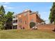 Expansive backyard showcases a brick home with multiple decks, lush lawn, and inviting chairs for relaxation at 5080 Riverlake Dr, Peachtree Corners, GA 30097