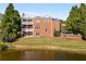 Brick home overlooks lush lawn and tranquil pond, creating a private and serene outdoor living space at 5080 Riverlake Dr, Peachtree Corners, GA 30097