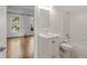 Bright white bathroom with tub, tile surround, modern vanity, and wood floor outside in connected room at 5080 Riverlake Dr, Peachtree Corners, GA 30097